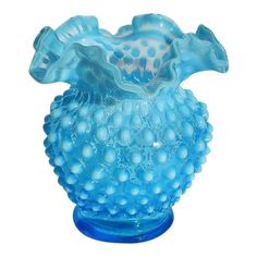 a blue glass vase sitting on top of a table