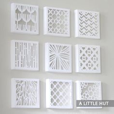 paper cut designs are arranged on the wall in different shapes and sizes, including square ones