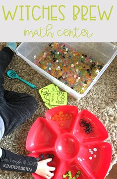 a child playing with witches brew math center on the floor next to a plastic tray