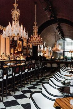 an elegant restaurant with chandeliers and black and white checkerboard flooring