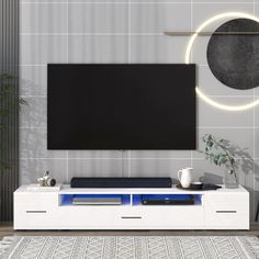 a modern living room with a large flat screen tv on the wall and blue accents