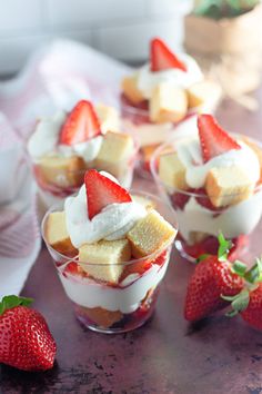 small desserts with strawberries and marshmallows are on the table next to each other