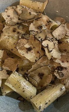 a bowl filled with pasta and mushrooms covered in seasoning