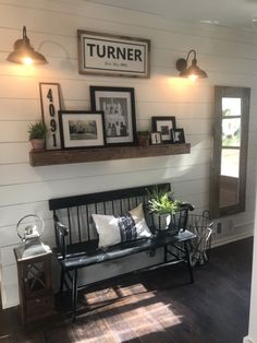 a bench sitting in the middle of a room with pictures on the wall above it