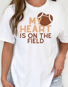 My heart is on the field graphic tee, football season shirt, football mom shirt, football tshirt This is the perfect shirt to wear this football season, look cute while you cheer heart on! MATERIAL & FEATURES * 100% combed and ring-spun cotton (Heather colors contain polyester) * Pre-shrunk fabric * Side-seamed construction * Shoulder-to-shoulder taping SIZING Please note that majority of the shirts are UNISEX to ensure inclusivity and tailor to every beautiful and unique body type. Also please Football Season Sports Fan T-shirt With Text Print, Sports Fan T-shirt With Text Print For Football Season, Graphic Tee For Football Season With Heat Transfer Vinyl, White T-shirt With Heat Transfer Vinyl For Football Season, Football Season Letter Print T-shirt, Football Mom Shirts, Shirt Football, Football T Shirt, Mama Shirts