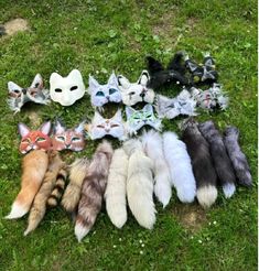 a group of cat masks sitting on top of a grass covered field next to each other