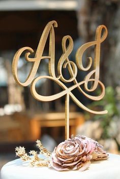 there is a wedding cake with the initials on it and a rose in the middle