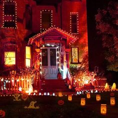 a house decorated for halloween with pumpkins and lights