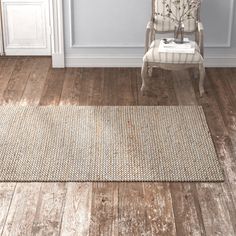 a white chair sitting on top of a hard wood floor next to a wooden floor