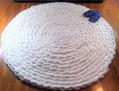 a large white round rug on top of a wooden floor