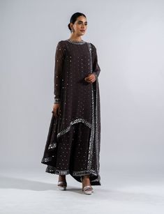 Editor's Note Featuring a charcoal grey real hand cut mirror and cheeta work asymmetrical kurta paired with palazzo pants and a dupatta Fabric: Georgette, lining: silk blend Color: Charcoal grey Component: Kurta, palazzo and dupatta Occasion: Wedding Guest Care: Dry Clean Only About the Designer Vvani by Vani Vats- an Indian ethnic women’s wear label. It is a depiction of the royal and intricate handcrafted embroideries in unconventional designs. Kurta Set With Dupatta, Vani Vats, Palazzo Set, Indian Wedding Wear, Pattern Embroidery, Thread Embroidery, Kinds Of Clothes, New Fashion Trends, Mirror Work