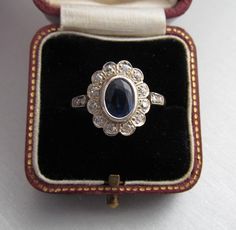 Antique diamond and kyanite cluster engagement ring, made of 14K gold and silver combination. It has a 14K gold hallmark that was used between 1867 and 1937. It was made in Austria. Total diamond weight: 0.35 carat Size of the kyanite stone: 0.291 x 0.224 inches (7.4 x 5.7 mm) Size of the head part: 0.563 x 0.469 inches (14.3 x 11.9 mm) Inside diameter: 0.6972 inches (17.71 mm) Size 7½ US Weight: 3.4 gram The box is not part of the auction. Free world-wide shipping by FedEx. Vintage Sapphire Cluster Ring With Gemstones, Antique Sapphire Ring With 17 Jewels, Antique White Gold Sapphire Ring With 17 Jewels, Hallmarked Cluster Sapphire Ring For Wedding, Vintage Sapphire Oval Cluster Ring, Vintage Sapphire Cluster Ring With Oval Shape, Vintage Sapphire Cluster Ring, Victorian Style Cluster Ring In White Gold As Gift, Victorian Style White Gold Cluster Ring As Gift