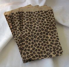 two pieces of paper with brown and black animal print on white fabric, next to each other