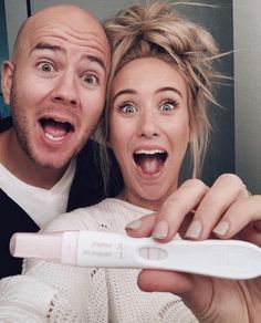 a man and woman taking a selfie with a toothbrush