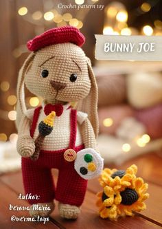 a crocheted bunny is standing next to a small toy sunflower on a table