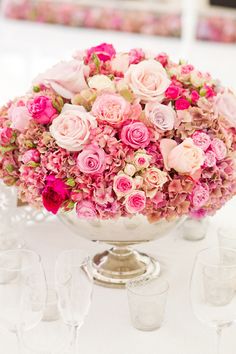 a vase filled with lots of pink flowers on top of a table