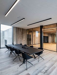 an empty conference room with black tables and chairs