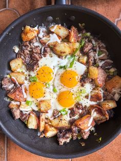 fried eggs and potatoes in a skillet on a table