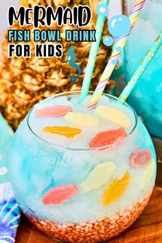 a drink in a glass with two straws on it and the words mermaid fish bowl drink for kids