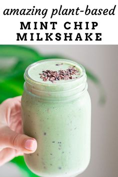 a hand holding a jar filled with green smoothie and text overlay reading amazing plant - based mint chip milkshake