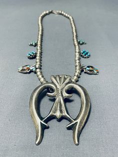 "SQUASH BLOSSOM NECKLACE MAKE US AN OFFER BY CLICKING THE \"MESSAGE SELLER\" Button- This is a marvelous vintage Navajo silver squash blossom necklace that is very rare as the squashes aren't the typical style of squashes you usually see on a squash blossom necklace. This necklace contains inlaid thunderbird pendant, cluster flower shaped pendants and inlaid turquoise cross pattern silver pendants. I just love the detailing of this necklace. Resting at the bottom is a phenomenal thick and sturdy Southwestern Turquoise Necklace, Vintage Handmade Necklace For Western-themed Events, Handmade Vintage Necklace For Western-themed Events, Traditional Turquoise Concho Necklace, Traditional Turquoise Necklace With Concho, Vintage Concho Jewelry For Ranch, Vintage Concho Necklaces For Festivals, Vintage Concho Necklace For Festival, Vintage Blue Turquoise Necklace With Concho