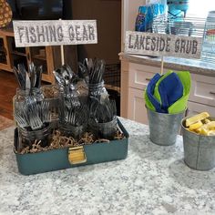 there is a fishing gear stand in the kitchen with other items on the counter and two buckets full of fish