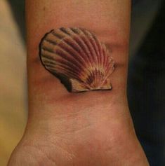 a small shell tattoo on the wrist