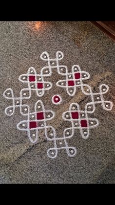 an intricate design on the ground in white and red