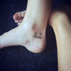 a woman's foot with a cat tattoo on the top and bottom of it