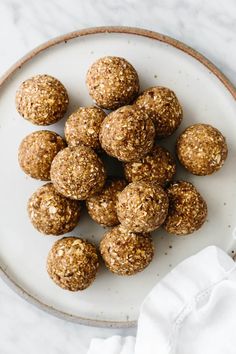 a white plate topped with cookies and oatmeal balls on top of a table