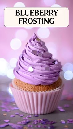 a purple frosted cupcake sitting on top of a table