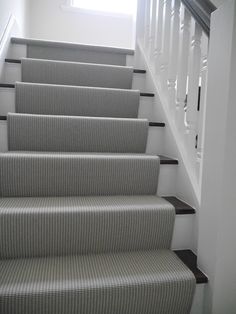 a set of stairs leading up to a window in a room with white walls and carpet