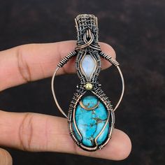 Note : Due to the natural formation of this gemstone. Slight variation in design and color are to be expected. Tibetan Turquoise Copper Pendant Wire Wrapped Gemstone Pendant Rainbow Moonstone Pendant Copper Wire Wrap Jewelry Handmade Pendant For Gifts Handmade Copper Pendant SKU : VFWP-4421 Gemstone : 1: Tibetan Turquoise                       2: Rainbow Moonstone Stone Shape : 1: Oval                           2: Oval Metal Purity : Copper Pendant Length : 80 MM   Pendant Width : 42 MM It is al Handmade Aquamarine Pendant Necklace, Aquamarine Pendant Jewelry With Natural Stones, Aquamarine Pendant With Natural Stones, Bohemian Aquamarine Jewelry In Turquoise, Bohemian Aquamarine Turquoise Jewelry, Bohemian Aquamarine Jewelry, Bohemian Turquoise Aquamarine Jewelry, Bohemian Turquoise Gemstones For Gifts, Nature-inspired Turquoise Gemstone Beads Jewelry