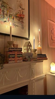 a fireplace with candles and books on it