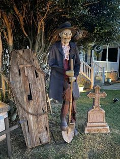 a scarecrow standing next to two tombstones