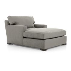 a white couch with a footstool and pillows on it's back end