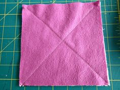 a pink piece of fabric sitting on top of a cutting board