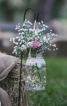 a vase filled with flowers sitting on top of a hay bale