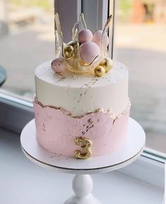 a pink and white cake sitting on top of a window sill