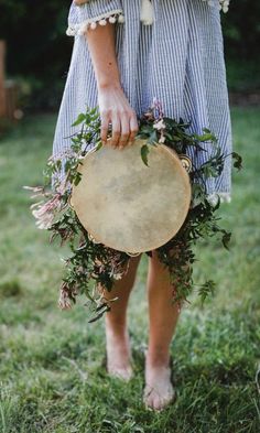 a person holding a round object in their hand with plants on it and the caption below