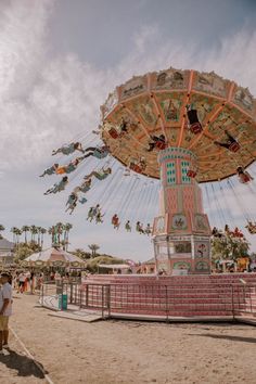 people are flying in the air at an amusement park with a carousel and swing ride