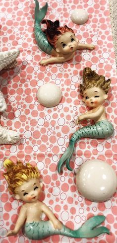 some little figurines sitting on top of a pink and white table cloth with polka dots