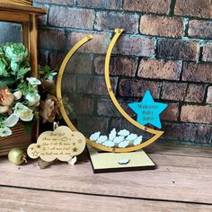 a wooden star and moon decoration on top of a table next to a brick wall