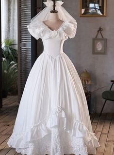 a white wedding dress on display in a room