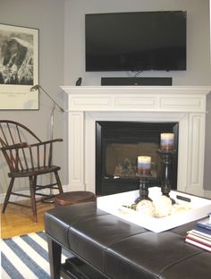 a living room with a large flat screen tv above the fireplace