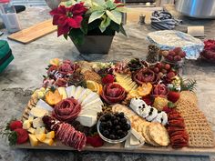 an assortment of cheeses, crackers and fruits on a tray