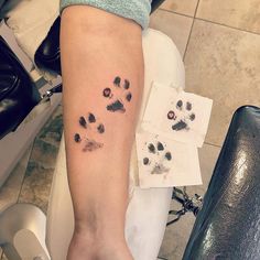 a person with a tattoo on their arm and paw prints in the middle of it