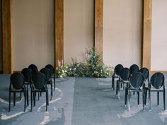 rows of black chairs are lined up in front of a floral arrangement on the floor