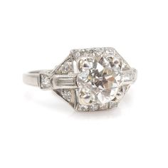 A perfect Art Deco engagement ring. A 1.75 ct Old European Cut diamond (G VS2) is flanked on either side by a baguette diamond (0.14 ct total, F VS1). The entire ring is outlined by 0.30ct of F VS2 round diamonds, bringing the total carat weight to 2.19 ct. The ring is made of platinum. We must say, it is rare to find a high color, high clarity stone and have it be an old fashioned cut. When the modern brilliant first arrived, a lot of people took their good diamonds and had them recut in an eff Old Mine Cut Diamond, Art Deco Engagement, Deco Engagement Ring, Art Deco Engagement Ring, European Cut Diamonds, Platinum Ring, Best Diamond, Baguette Diamond, Nashville Tn