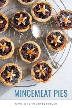 several small pastries on a wire rack with a spoon in the middle and star decorations on top